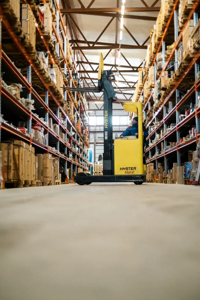 A yellow forklift in a large warehouse